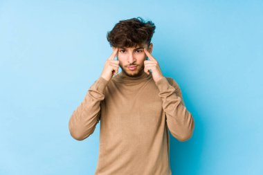 İzole edilmiş genç Arap bir adam bir göreve odaklanmış, işaret parmaklarını işaret ediyor..