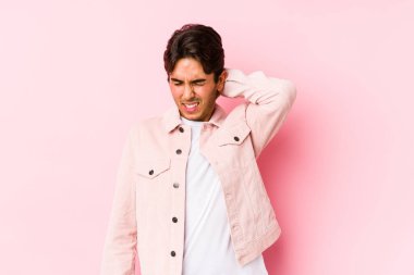 Pembe arka planda poz veren beyaz bir genç sabit yaşam tarzından dolayı boyun ağrısı çekiyor..