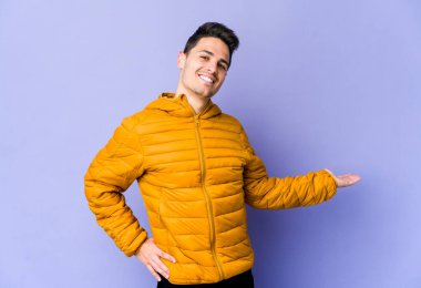 Mor arka planda izole edilmiş beyaz bir genç hoş bir yüz ifadesi sergiliyor..