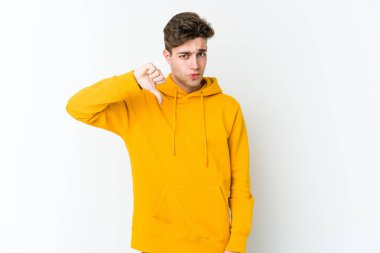 Beyaz arka planda izole edilmiş genç beyaz adam baş parmağını aşağı gösteriyor, hayal kırıklığı konsepti..