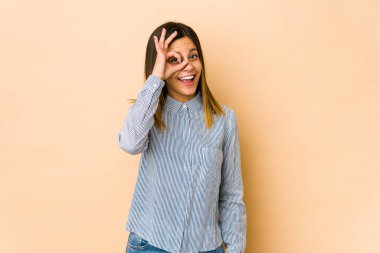 Bej arka planda izole edilmiş genç bir kadın heyecanlı..