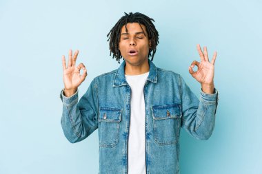 Kot ceket giyen genç siyah adam sıkı çalışma gününden sonra rahatlıyor, o yoga yapıyor..