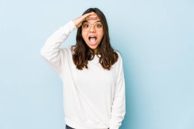 Genç melez İspanyol kadın izole edilmiş yüksek sesle bağırıyor, gözleri açık ve elleri gergin tutuyor..