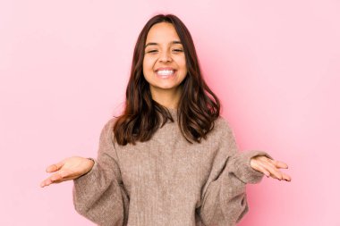 Latin kökenli genç bir kadın avuçlarıyla bir şey tutup kameraya sunuyor..