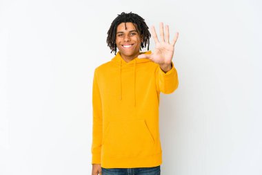Genç Afrikalı Amerikalı Rasta adam gülümseyerek beş numarayı parmaklarıyla gösteriyor..
