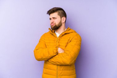 Mor arka planda izole edilmiş genç bir adam şüpheli, belirsiz, seni muayene ediyor..