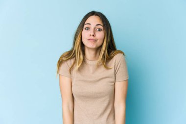 Mavi arka planda soyutlanmış beyaz bir kadın omuzlarını silker ve gözleri açık kalır..