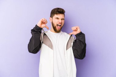 Mor arka planda izole edilmiş genç adam gururlu ve kendinden emin hissediyor, örnek olarak..