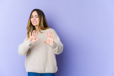 Mor arka planda izole edilmiş beyaz bir kadın iğrenme belirtisi gösteren birini reddediyor..