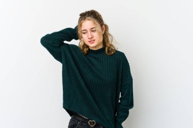 Beyaz arka plandaki genç beyaz kadın yorgun ve uykulu. Elini başının üstünde tutuyor..