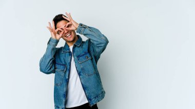 Beyaz arka planda izole edilmiş genç beyaz bir adam gözlerinde sorun olmadığını gösteriyor.