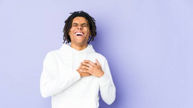 Genç Afrikalı Amerikalı Rasta adam gülüyor. Elini yüreğine koyuyor. Mutluluk kavramı..