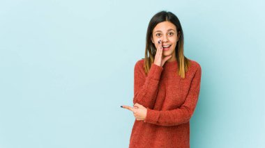 Mavi arka planda izole edilmiş genç bir kadın bir dedikodu söylüyor, bir haber sunuyor..