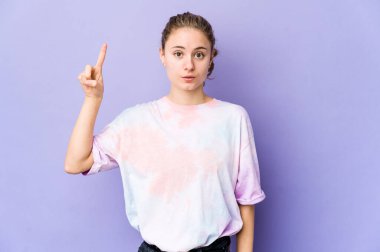 Mor arka planda genç beyaz bir kadının harika bir fikri var, yaratıcılık kavramı..