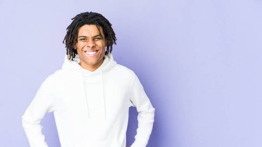 Genç Afro-Amerikan Rasta Adam kendine güveniyor. Kalçalarını tutuyor..