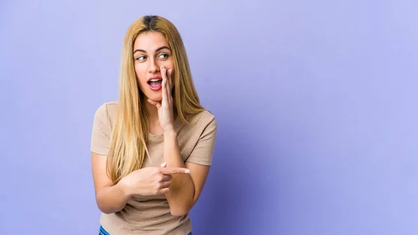 Jovem Loira Isolada Fundo Roxo Dizendo Uma Fofoca Apontando Para — Fotografia de Stock