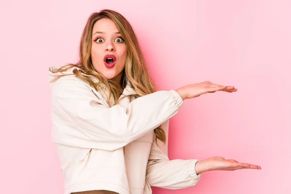 Joven Mujer Caucásica Aislada Sobre Fondo Rosa Sorprendida Sorprendida Sosteniendo — Foto de Stock