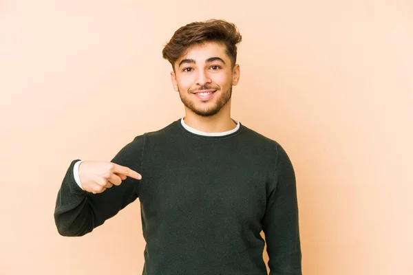 Hombre Árabe Joven Aislado Fondo Beige Persona Señalando Mano Espacio — Foto de Stock