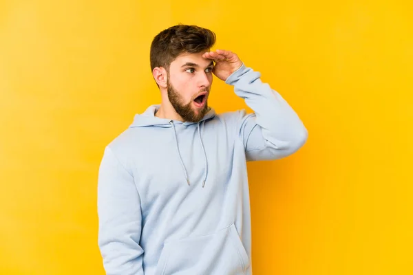 Joven Hombre Caucásico Aislado Sobre Fondo Amarillo Mirando Lejos Manteniendo — Foto de Stock