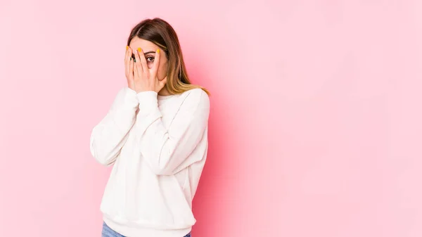 Mujer Joven Caucásica Aislada Sobre Fondo Rosa Parpadea Través Los —  Fotos de Stock