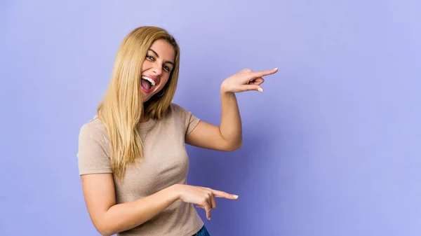 Jong Blond Vrouw Geïsoleerd Paars Achtergrond Opgewonden Wijzend Met Wijsvingers — Stockfoto