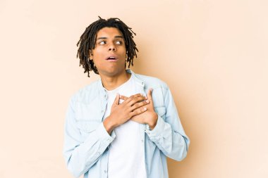 Genç Afro-Amerikan Rasta Adam 'ın dost canlısı bir ifadesi var. Avuçlarını göğsüne bastırıyor. Aşk konsepti.