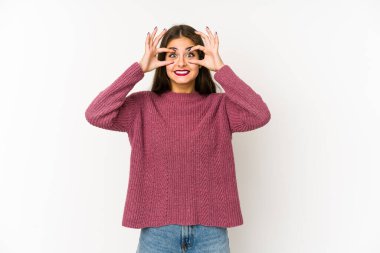 Beyaz arka planda izole genç beyaz kadın bir başarı fırsatı bulmak için gözlerini açık tutuyor..