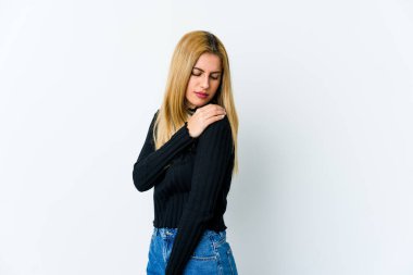 Beyaz arka planda izole edilmiş genç sarışın kadın omuz ağrısı çekiyor..