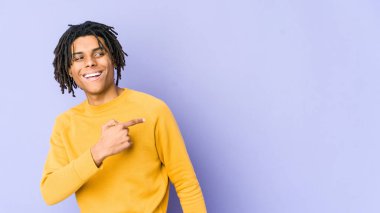 Rasta saç stili giyen genç siyahi adam gülümseyen, neşeli ve keyifli bakışlarını yana çevirir..