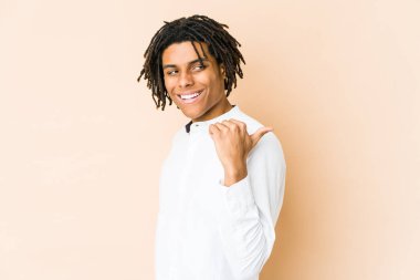 Genç Afro-Amerikan Rasta adamı parmağıyla işaret ediyor, gülüyor ve kaygısız..