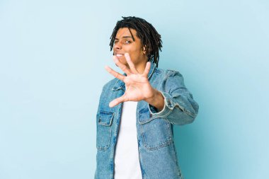 Kot ceket giyen genç siyahi bir adam tiksinti gösteren birini reddediyor..