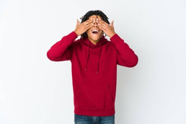 Genç Afrikalı Amerikalı Rasta adam elleriyle gözlerini kapatıyor, gülümseyerek bir sürpriz bekliyor..