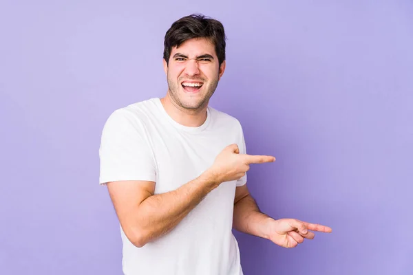 Young Man Isolated Purple Background Pointing Forefingers Copy Space Expressing — Stock Photo, Image