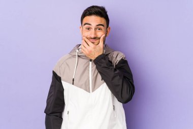 Mor arka planda izole genç beyaz adam iki seçenek arasında şüphe ediyor.