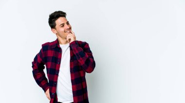 Beyaz arka planda izole edilmiş genç beyaz bir adam rahatlamış bir şeyin fotokopi odasına baktığını düşünüyor..