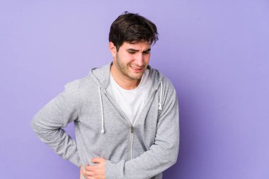 Mor arka planda izole edilmiş genç bir adam. Karaciğer ağrısı, mide ağrısı var..