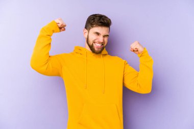 Mor arka planda izole edilmiş genç adam tasasız ve heyecanlı bir şekilde tezahürat yapıyor. Zafer konsepti.