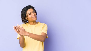 Genç Afro-Amerikan Rasta adamı enerjik ve rahat hissediyor, ellerini ovuşturup kendinden emin.