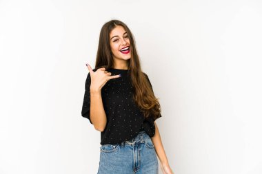 Beyaz arka planda izole edilmiş genç beyaz kadın parmaklarıyla bir cep telefonu hareketi gösteriyor..