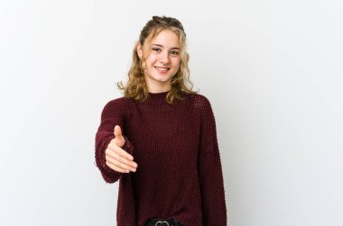 Beyaz arka planda genç beyaz bir kadın kameraya elini uzatarak selam veriyor..