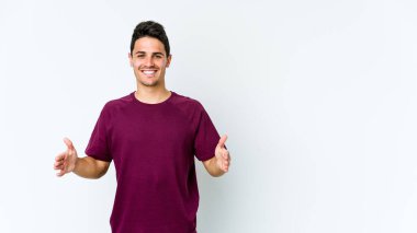 Beyaz arka planda izole edilmiş beyaz bir adam iki eliyle bir şey tutuyor..