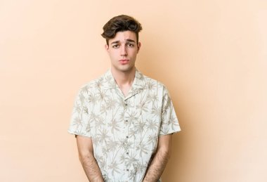 Beyazlı genç bir adam bej arka planda izole edilmiş üzgün, ciddi yüzlü, mutsuz ve hoşnutsuz..