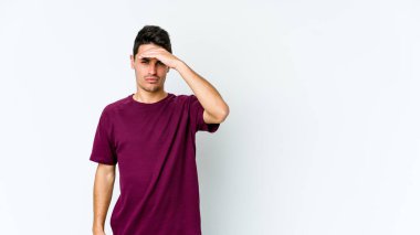 Beyaz arka planda izole edilmiş genç beyaz bir adam tapınaklara dokunuyor ve başı ağrıyor..