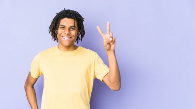 Genç Afrikalı Amerikalı Rasta adam iki numarayı parmaklarıyla gösteriyor..