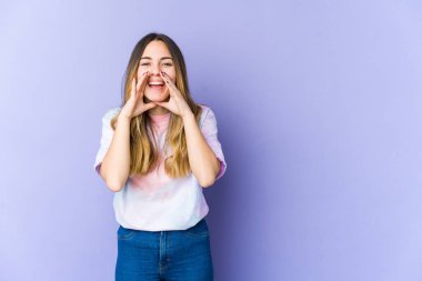 Mor arka planda izole edilmiş genç beyaz kadın bir dedikodu söylüyor, bir şeyleri haber veriyor..