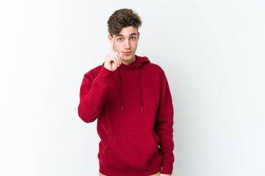 Beyaz arka planda izole edilmiş beyaz tenli genç bir adam bir numarayı parmağıyla gösteriyor..