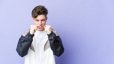 Mor arka planda izole edilmiş genç beyaz adam gergin ellerle çığlık atıyor..