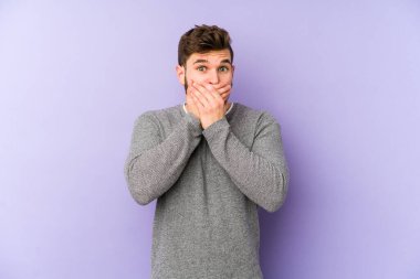 Mor arka planda izole edilmiş genç beyaz adam elleri ve ağzı endişeli görünüyor..