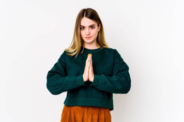 Beyaz arka planda izole edilmiş genç beyaz kadın dua ediyor, bağlılık gösteriyor, dindar biri ilahi ilhamı arıyor..