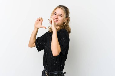 Beyaz arka plandaki genç beyaz kadın kendini gururlu ve kendinden emin hissediyor..